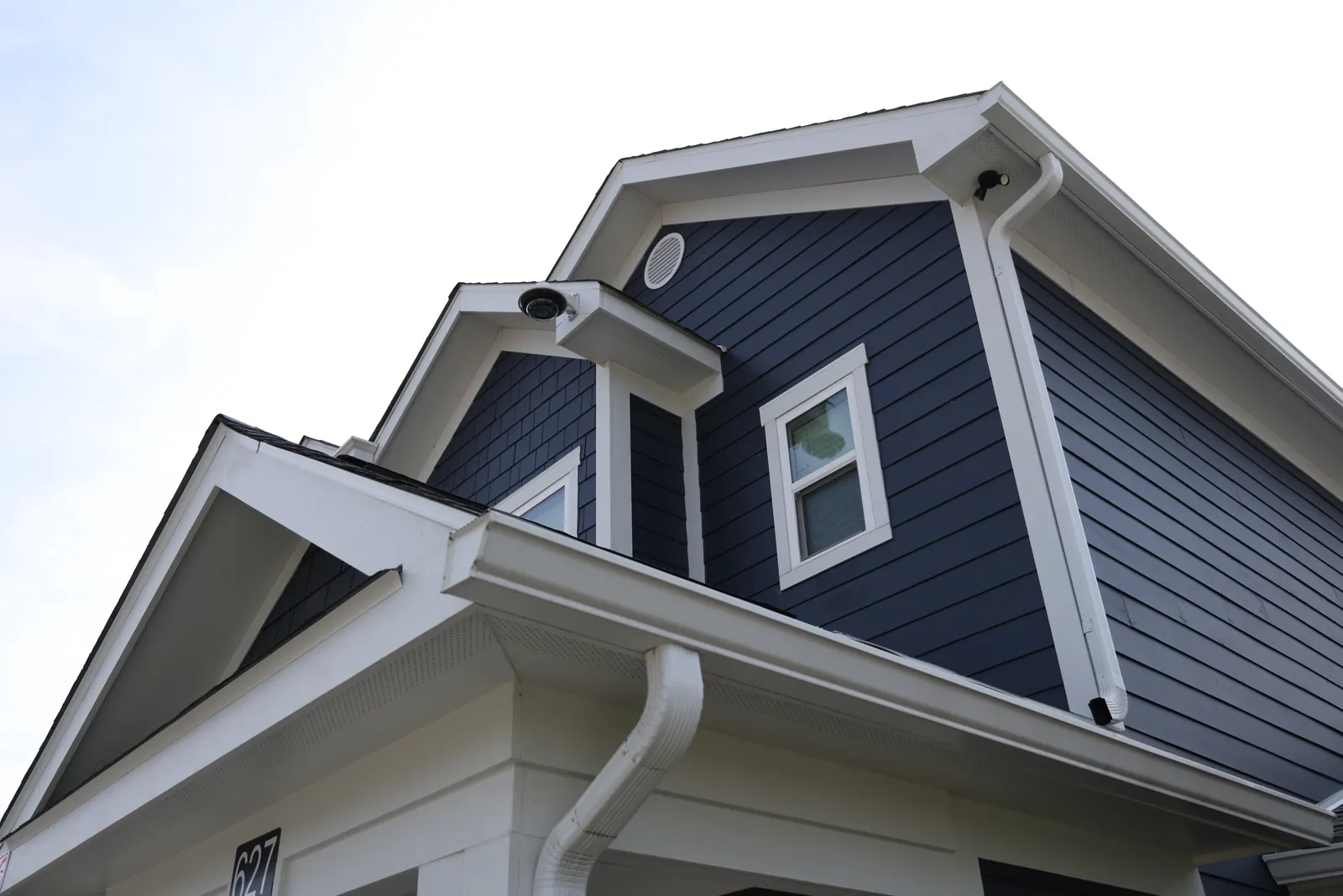 Navy lap siding, white trim and a gutter at Helen Ross