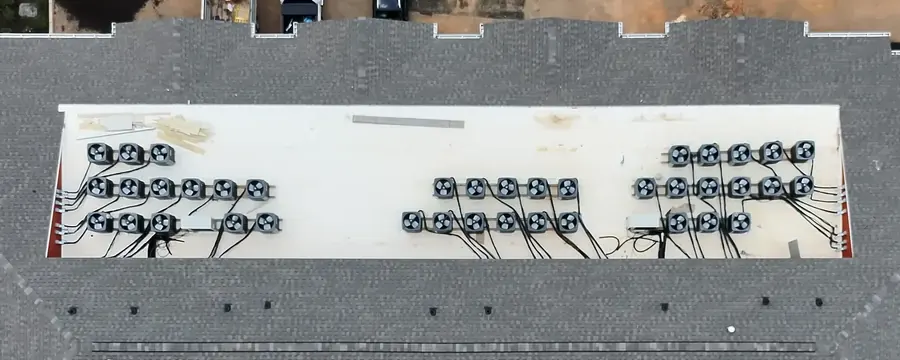Looking straight down on a flat membrane roof section lined with rooftop units